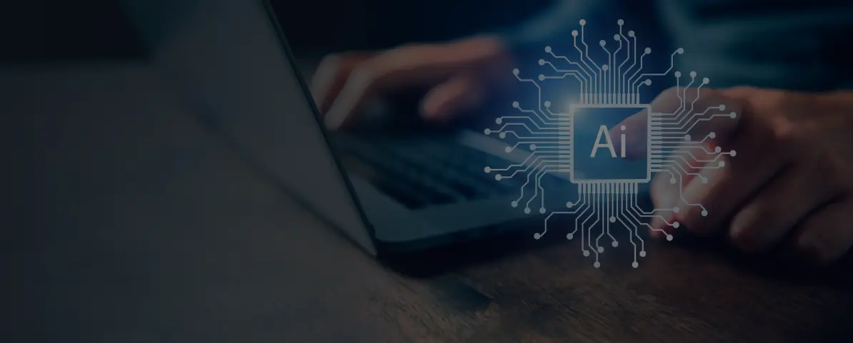 Person arbeitet an einem Laptop, daneben leuchtet ein KI-Symbol mit der Aufschrift ‚AI‘ in einem digitalen Schaltkreis