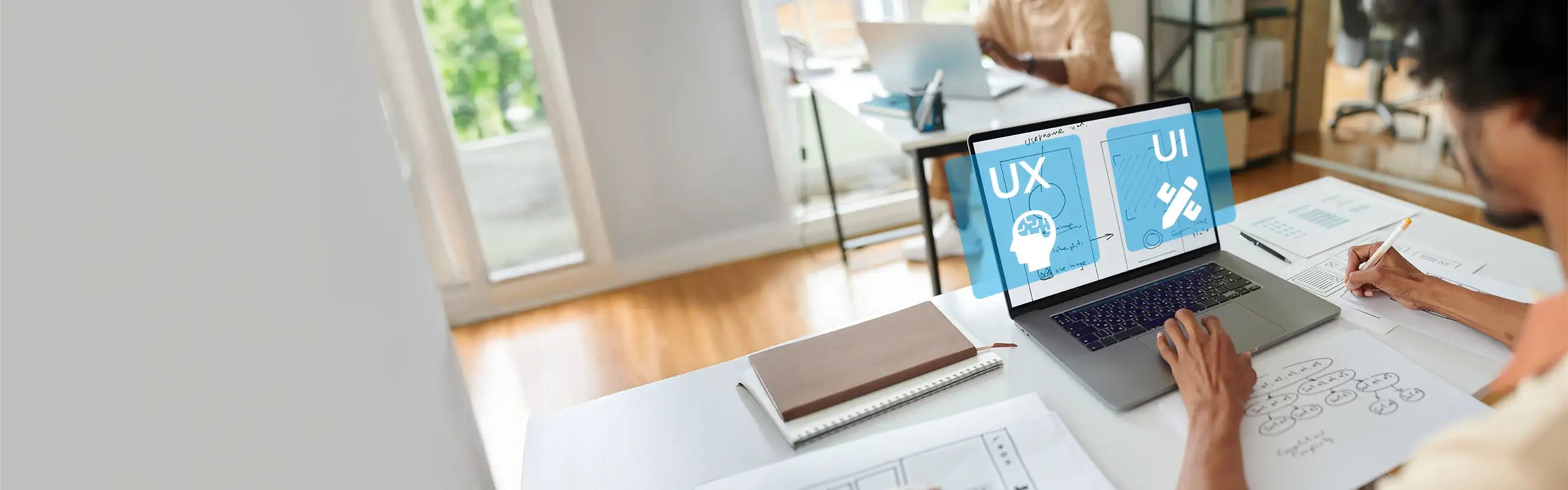 Webdesigner arbeitet an UX- und UI-Designs mit Wireframes auf dem Laptop – modernes Büro und User Experience-Prozess im Hintergrund.