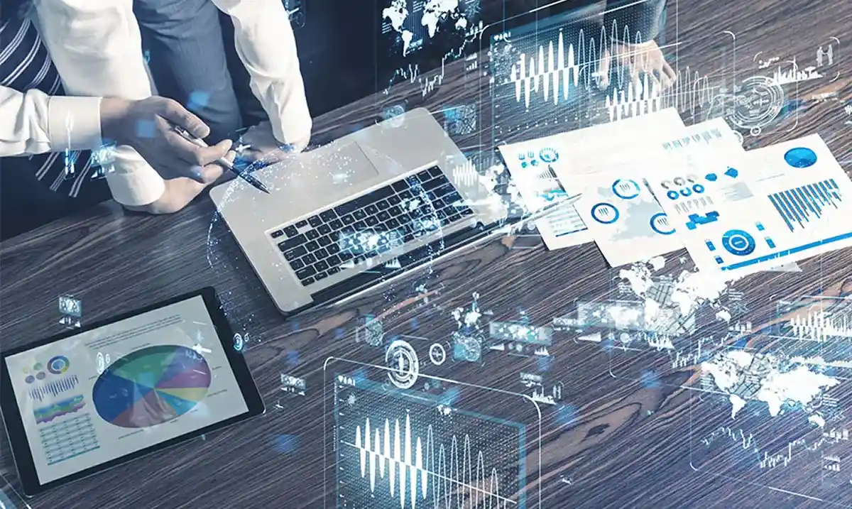 Beratungsgespräch an einem Tisch mit Laptop und Grafiken im Format 920x550