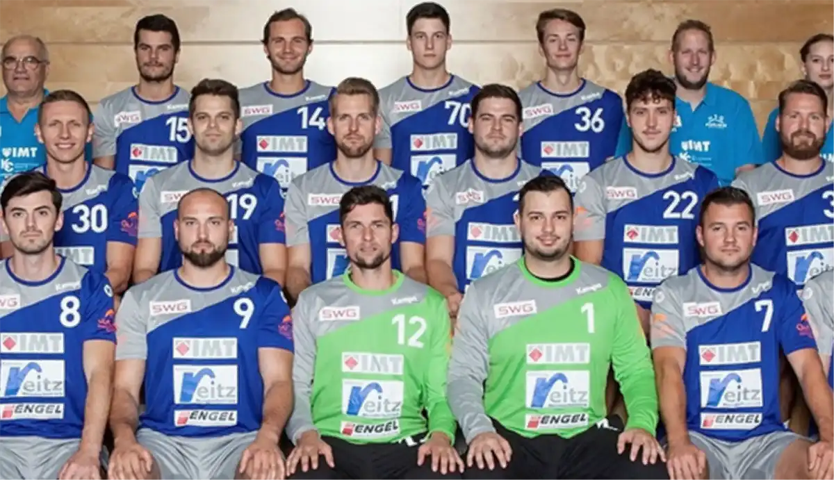 Eine Handballmannschaft posiert in ihren Trikots für ein Foto.