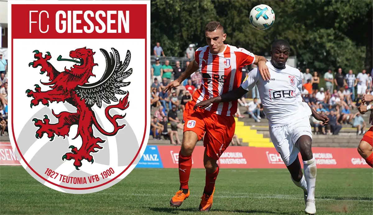 Auf der rechten Seite des Bildes sieht man zwei Fußballspieler, die im Zweikampf sind. Links ist das Wappen des FC Giessen zu sehen.