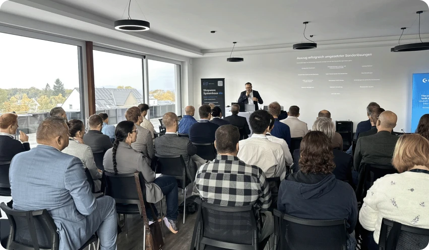 Teilnehmer bei einem Vortrag während des gemeinsamen Events von elio und Shopware 2024, aufmerksam zuhörend und Notizen machend