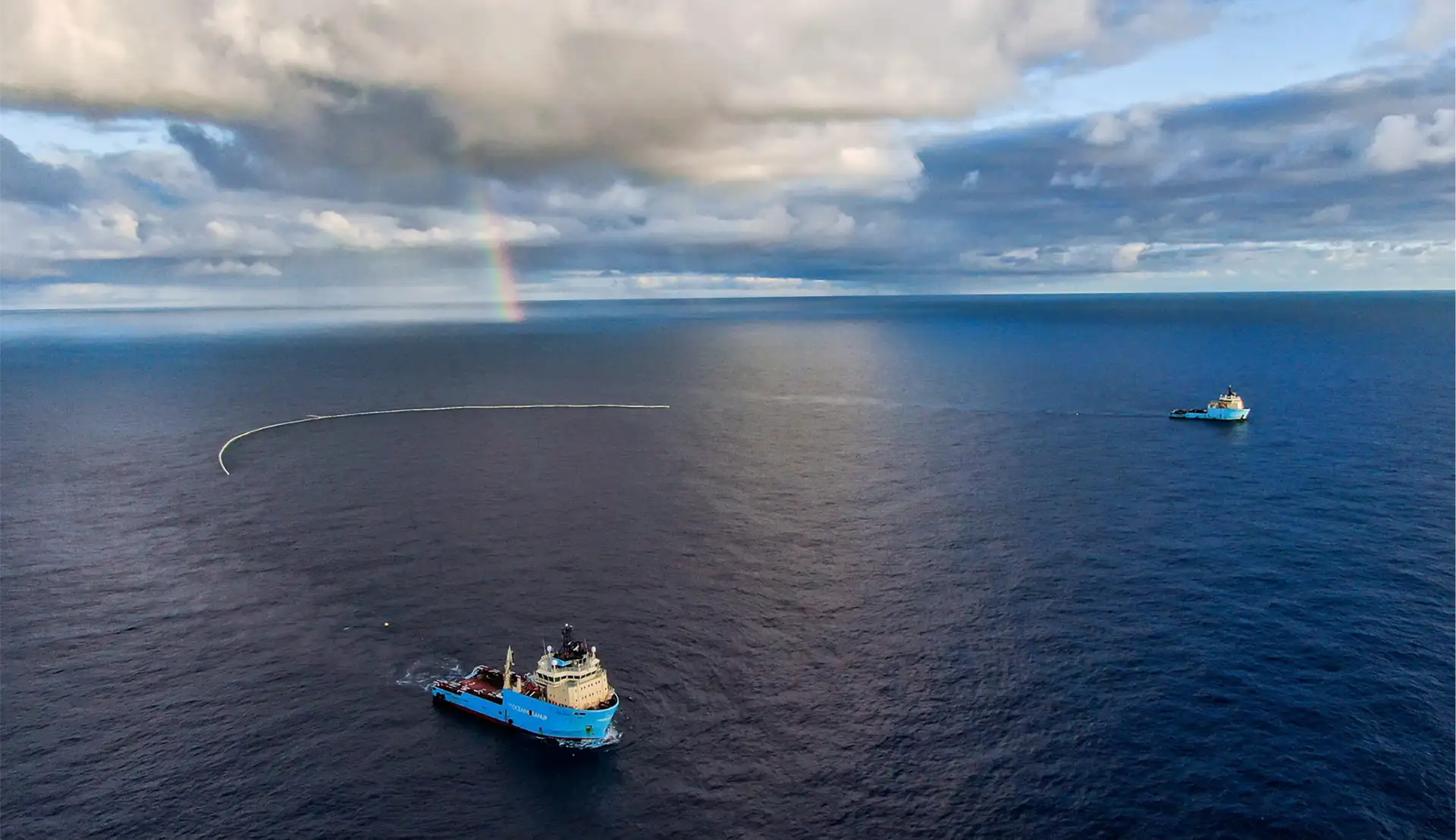 Zwei Schiffe fahren übers Meer und Sammeln mit einem Netz, welches zwischen den beiden Schiffen gespannt ist.